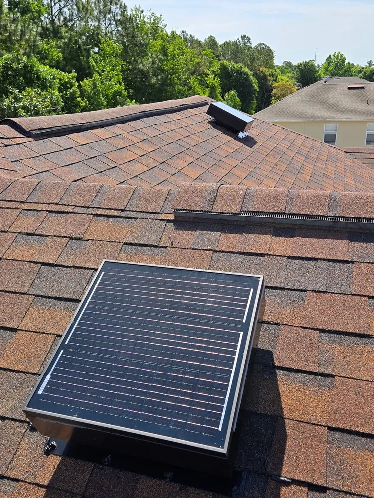 Low-profile solar attic fan seen from the street